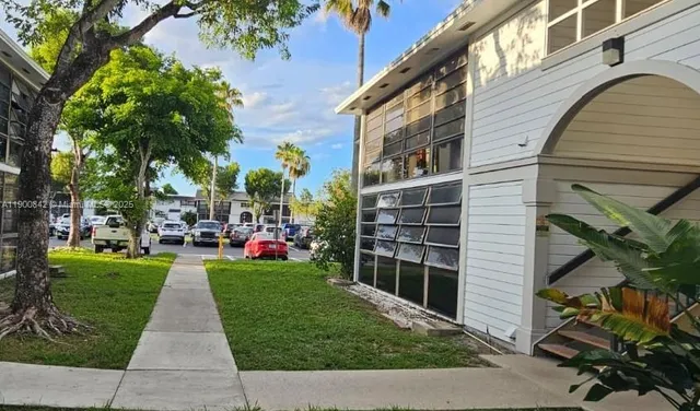 a front view of a building with a garden