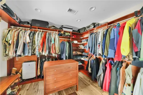 a view of walk in closet with clothes and shoes