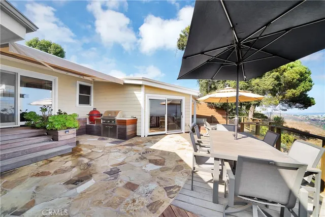 a view of a patio with a table and chairs under an umbrella