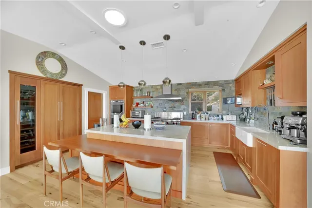 a large white kitchen with a large window and stainless steel appliances