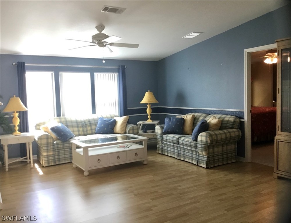 15550 Burnt Store Road, Unit 13 Punta Gorda, FL 33955 - Photo 13 of 30 a living room with furniture chandelier and a large window