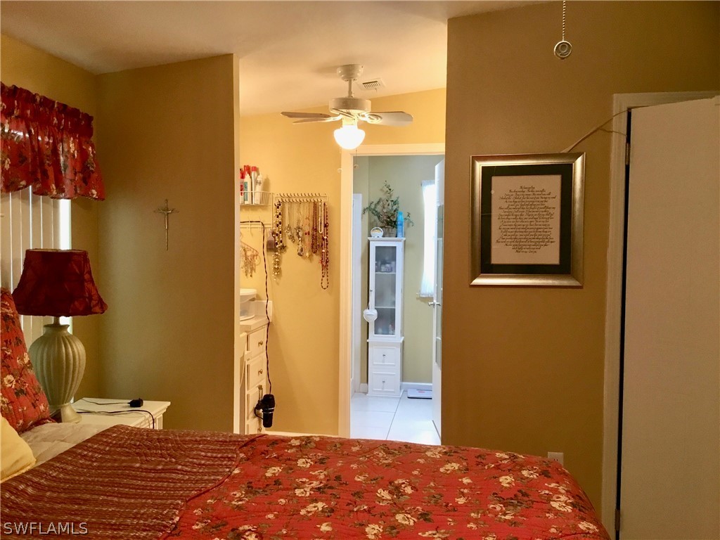 15550 Burnt Store Road, Unit 13 Punta Gorda, FL 33955 - Photo 16 of 30 a bedroom with a bed and a lamp with potted plant