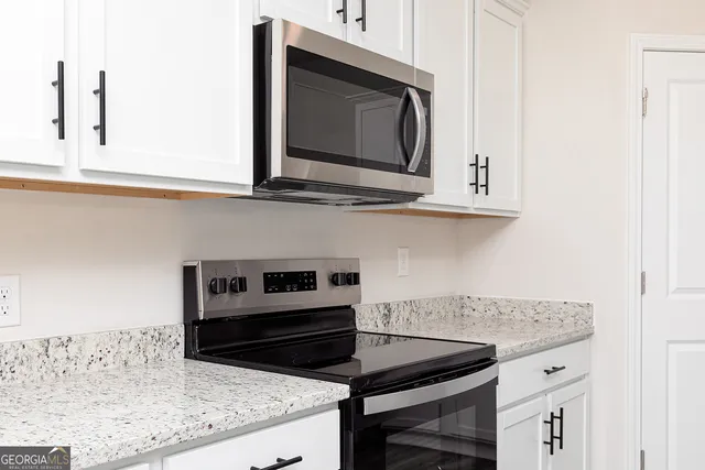 a kitchen with granite countertop a sink stainless steel appliances and cabinets