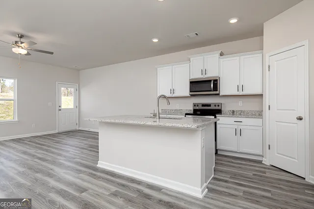 a kitchen with a refrigerator cabinets and wooden floor