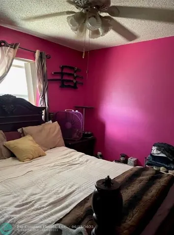 a bedroom with a bed and dresser with wooden floor