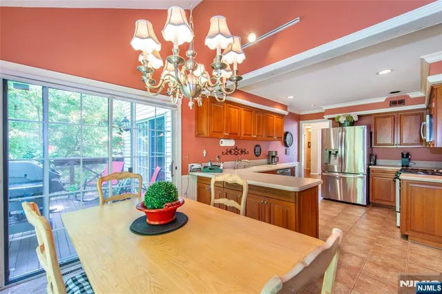 a kitchen with stainless steel appliances granite countertop a stove and a dining table with kitchen view