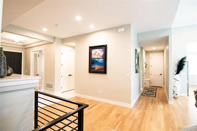 a view of a hallway with wooden floor and staircase