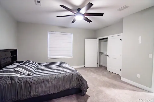 a bedroom with a bed and a ceiling fan