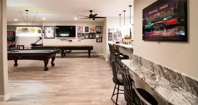 a living room with stainless steel appliances kitchen island furniture and a flat screen tv