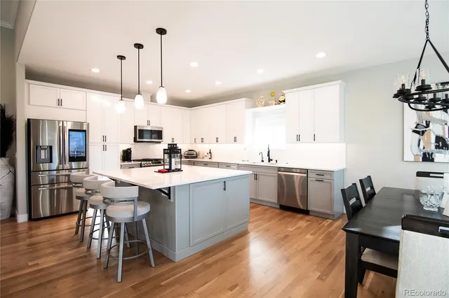 a kitchen with a sink a stove a refrigerator and chairs