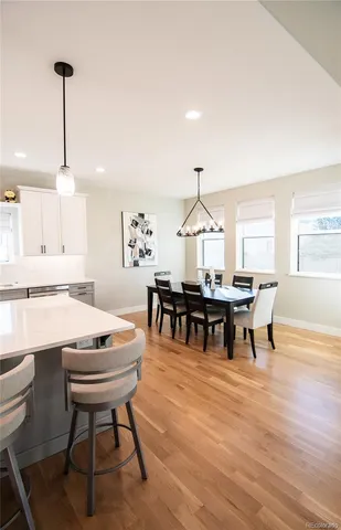 a living room with furniture a dining table and a potted plant