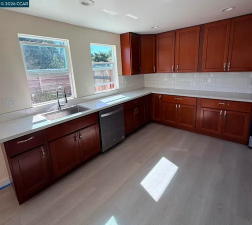 a kitchen with stainless steel appliances granite countertop a sink dishwasher stove and cabinets