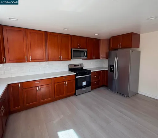 a kitchen with granite countertop stainless steel appliances and wooden cabinets