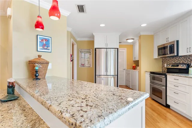 a kitchen with kitchen island sink refrigerator and microwave