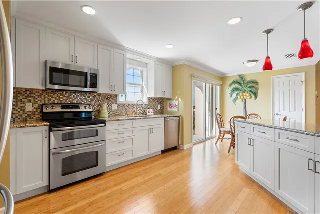 a kitchen with granite countertop a stove a sink and a microwave