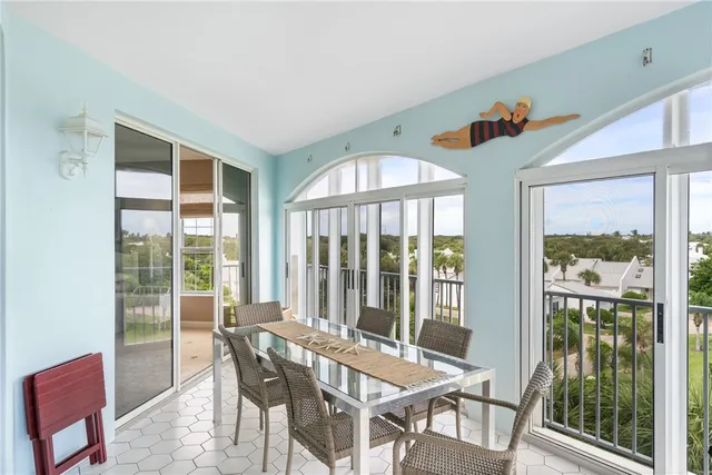 a view of a dining room with furniture large windows and wooden floor