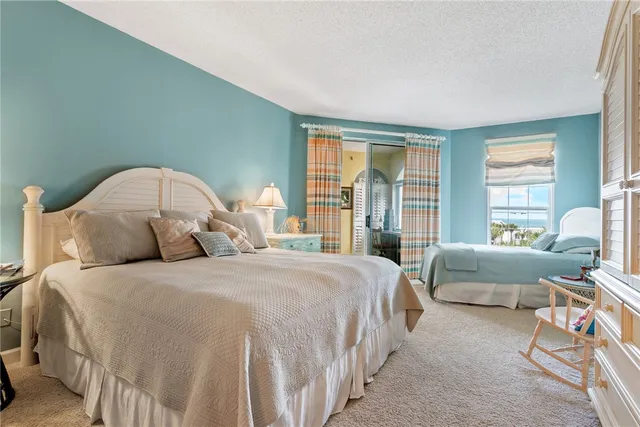 a bedroom with a bed and a couch next to a window