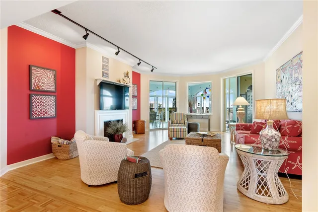 a living room with furniture a flat screen tv and floor to ceiling window