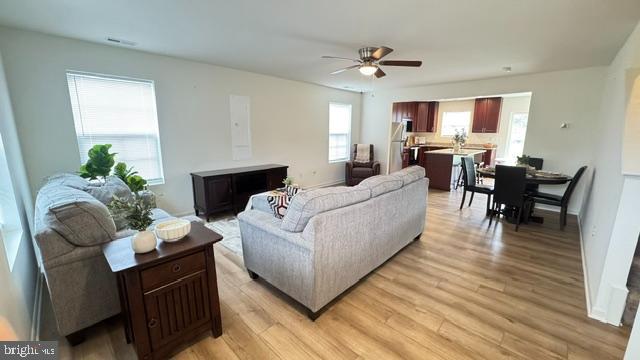 65 Chesterfield Road East Berlin, PA 17316 - Photo 6 of 32 a living room with furniture dining table a lamp potted plant and a window