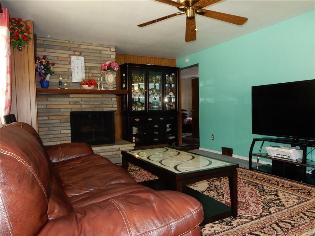 321 East Garden Road Pittsburgh, PA 15227 - Photo 6 of 20 Large living room with hardwood floors under the carpet, ceiling fan and wood burning fire place.