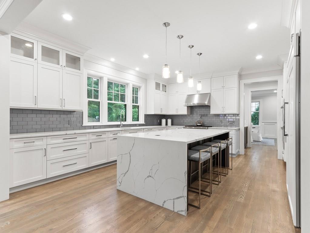 30 Columbine Road Newton, MA 02459 - Photo 7 of 35 a large kitchen with kitchen island a sink white cabinets and wooden floor
