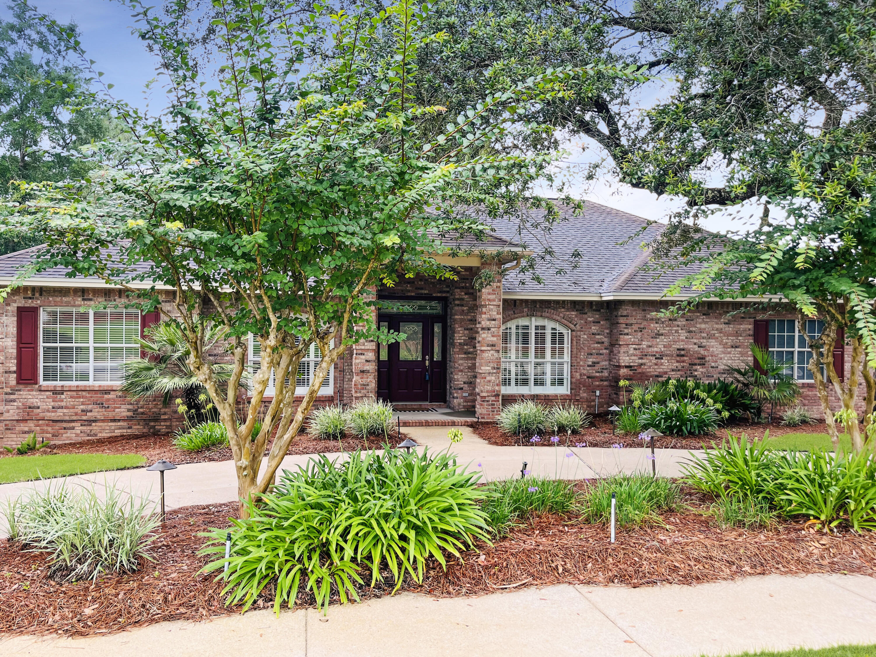 4100 Howard Drive Niceville, FL 32578 - Photo 3 of 133 a front view of a house with a garden and outdoor seating