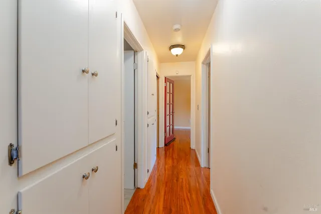 a view of a hallway with wooden floor and staircase