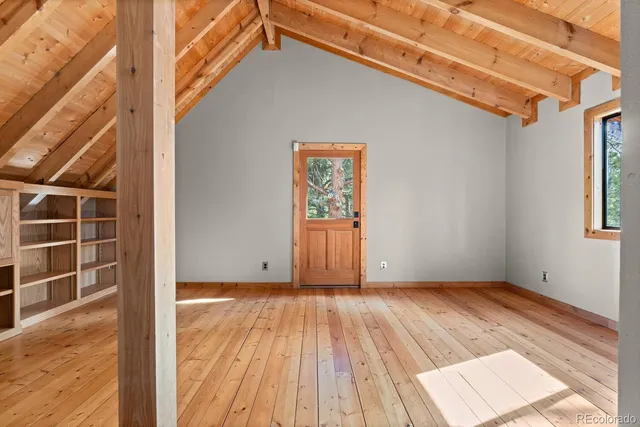 a view of empty room with wooden floor and cabinet