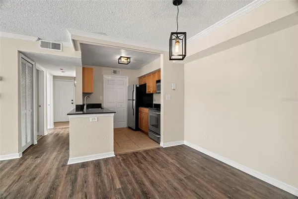 a kitchen with a refrigerator a stove top oven a sink and dishwasher with wooden floor