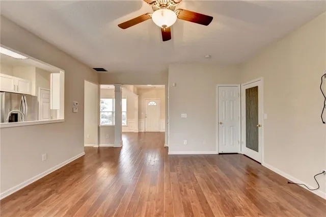 a view of an empty room and window with wooden floor