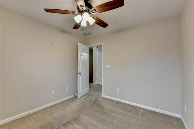 a view of a big room with wooden floor and a ceiling fan