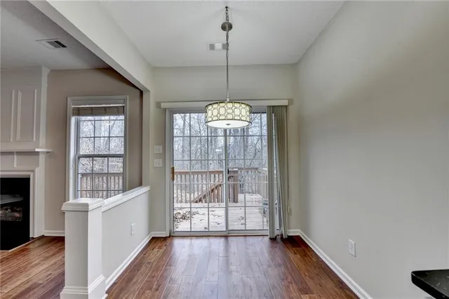 a kitchen with stainless steel appliances a stove a sink and white cabinets with wooden floor