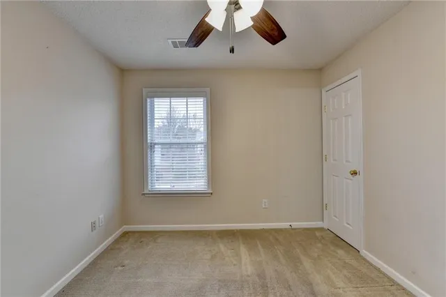 an empty room with a fan and a fan