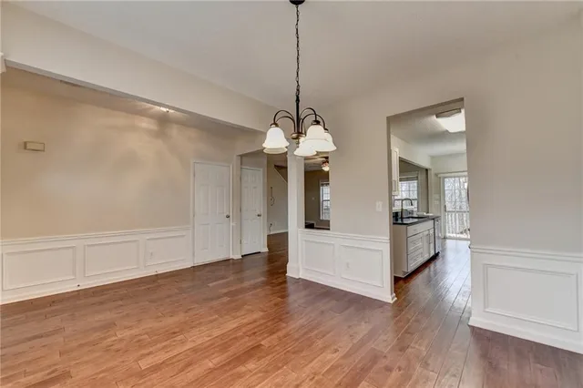 an empty room with windows a fireplace and wooden floor
