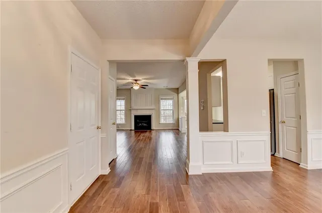 a view of a big room with wooden floor fireplace and windows