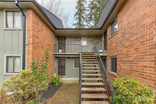 a view of a brick house with a large windows and flower plants