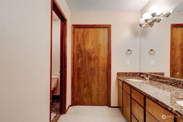 a bathroom with a granite countertop sink and a mirror