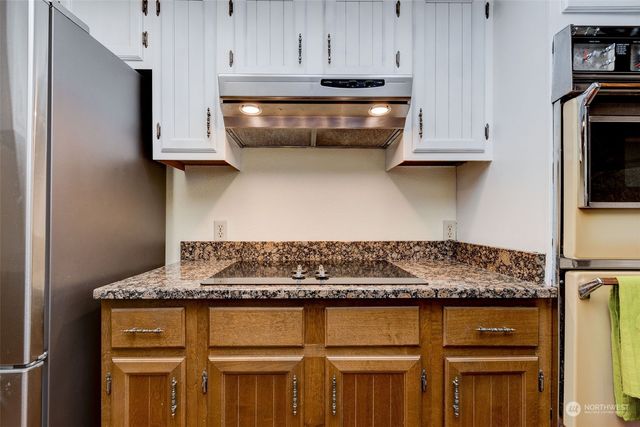 a kitchen with granite countertop a sink and cabinets