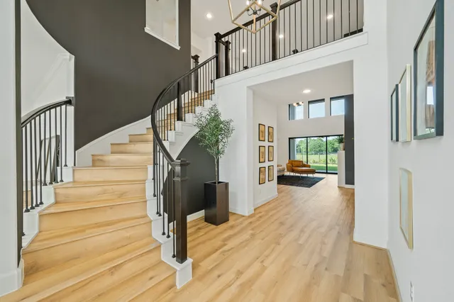 a living room with furniture kitchen view and a wooden floor