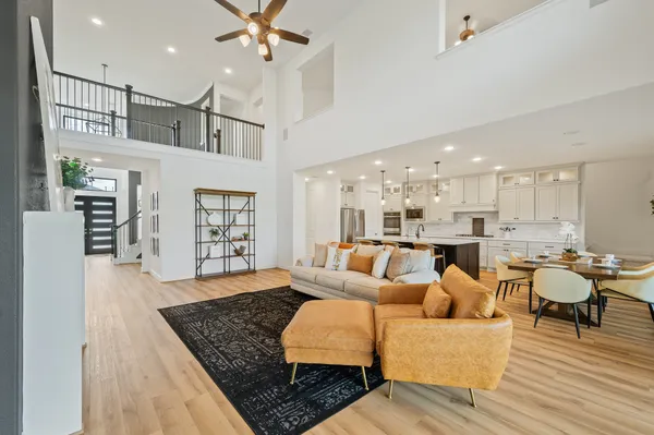 a living room with furniture kitchen view and a wooden floor
