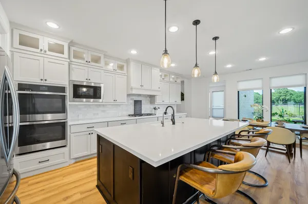 a kitchen with a stove a refrigerator and a dining table