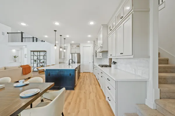 a large white kitchen with lots of counter space wooden floor and appliances