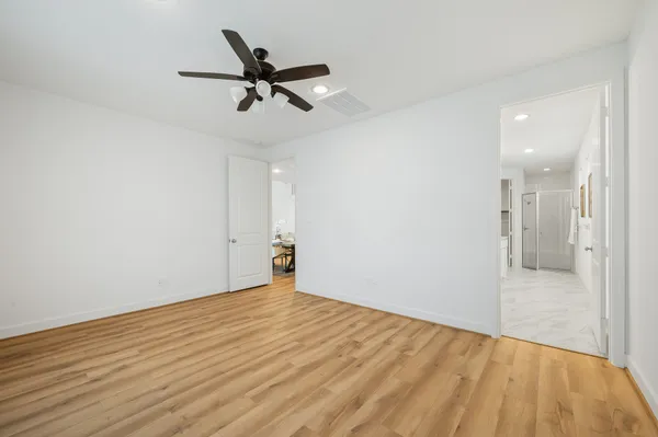 a view of a room with wooden floor and a ceiling fan