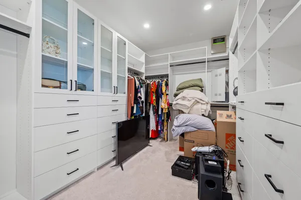 a view of walk in closet with clothes and shoes