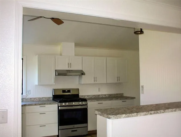 a kitchen with granite countertop a stove and a cabinets