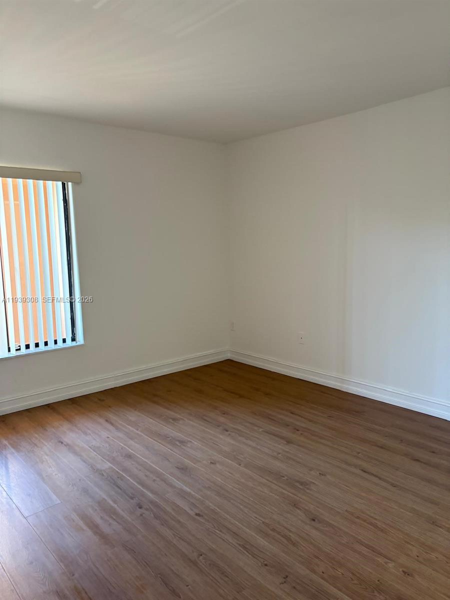 8700 Southwest 133rd Avenue Road, Unit 409 Miami, FL 33183 - Photo 3 of 10 a view of an empty room and wooden floor and window