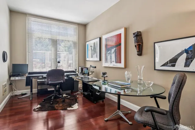 a view of a workspace with furniture and a window