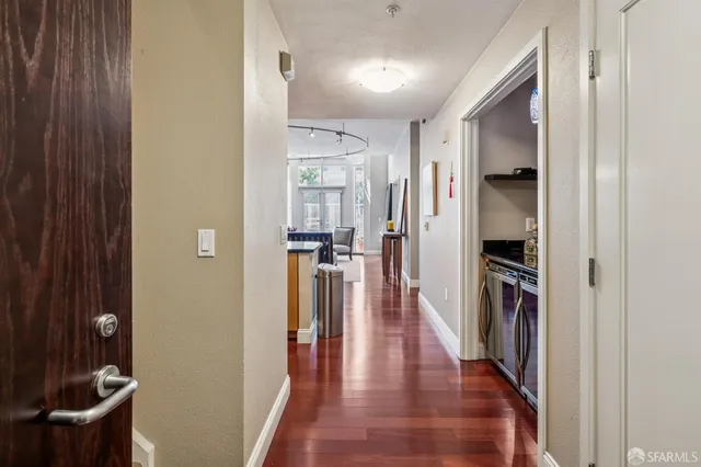 a hallway with wooden floor and staircase