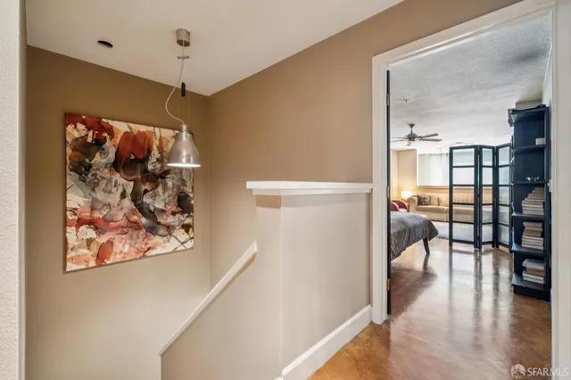 a hallway with wooden floor chandelier and entryway