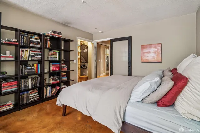 a bed sitting in a bedroom next to a book shelf